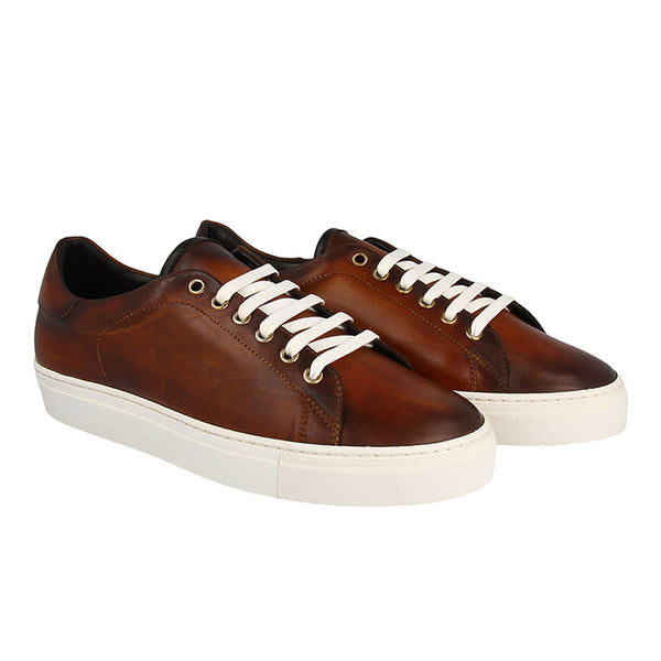 Men’s cognac patina leather sneakers with white rubber sole and contrast laces, handcrafted for style, comfort, and everyday versatility.