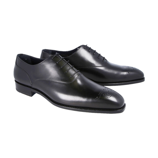 Black Oxford shoes with medallion toe design in full-grain leather, Goodyear welted and handcrafted in Portugal with soft chisel last and blue soles