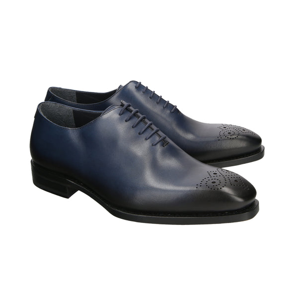 Dark navy whole-cut Oxford shoes with burnished black toe and medallion detail, handcrafted in French leather with Goodyear welt and chisel last.